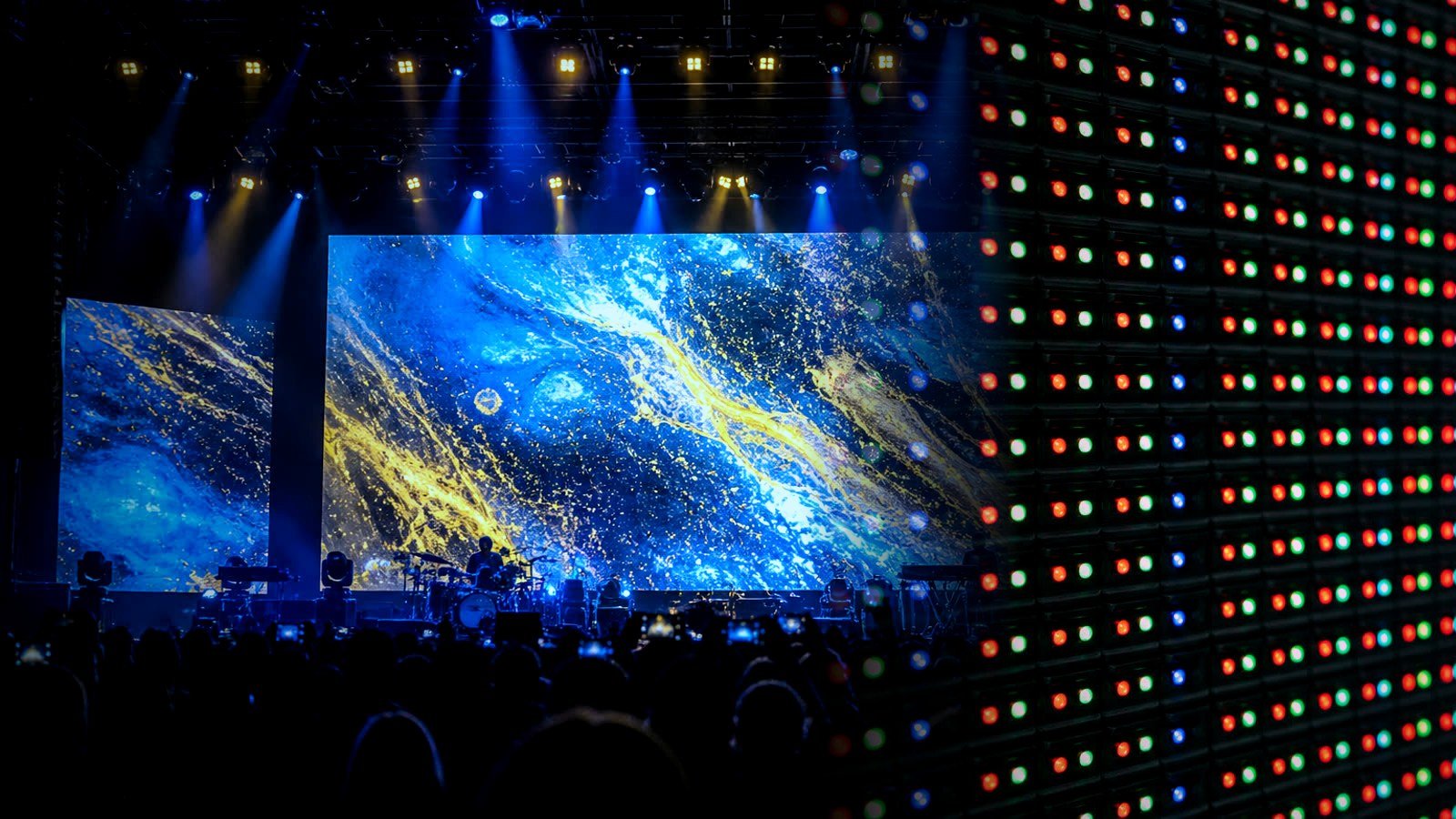 Concert-stage rental LED wall fading into a close-up RGB pixel grid, illustrating pitch at touring scale