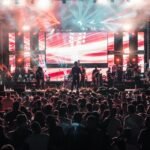 Live band performing on an outdoor festival stage with multi-panel LED backdrop and side strips
